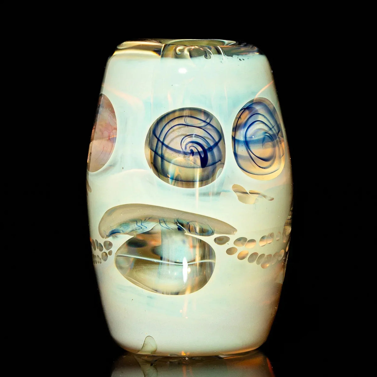 Handcrafted glass bead with abstract swirled patterns on a black background