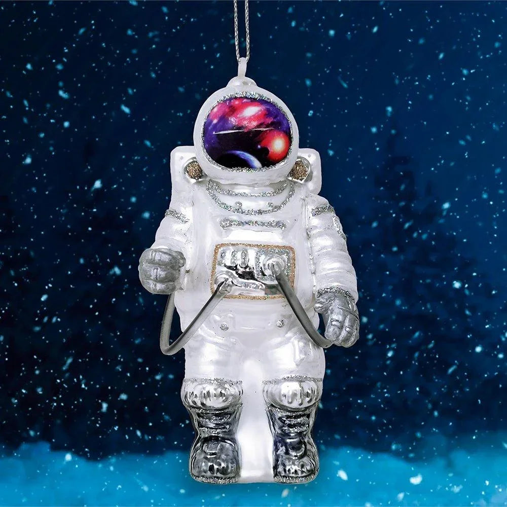 Hanging astronaut ornament with galaxy helmet in snowy night setting