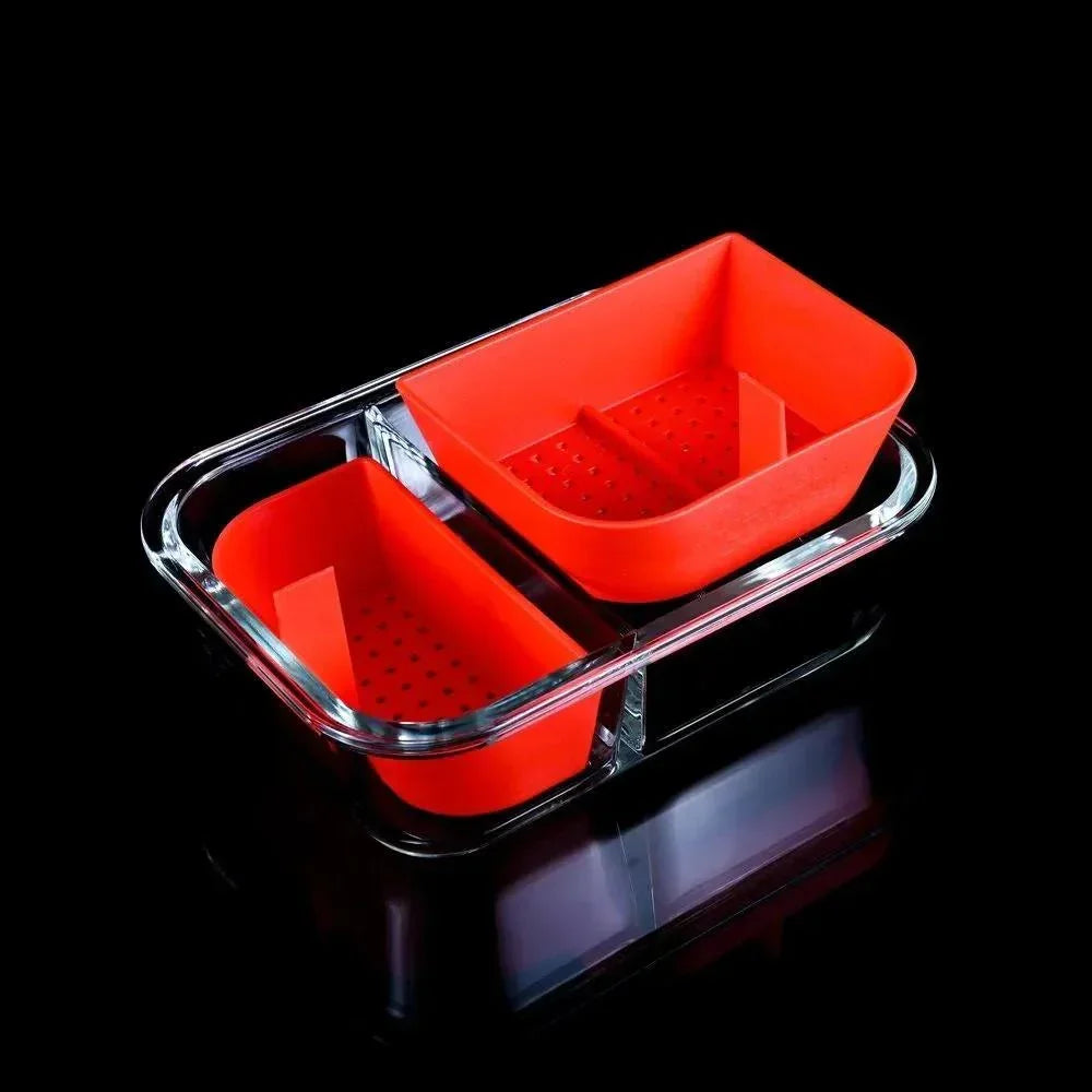 Red silicone and clear glass basket set with perforated trays on a black background