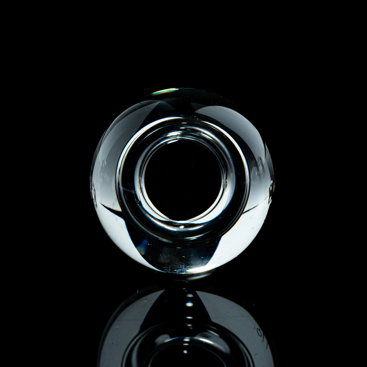 Toroidal clear glass marble on black background, heady glass accessory