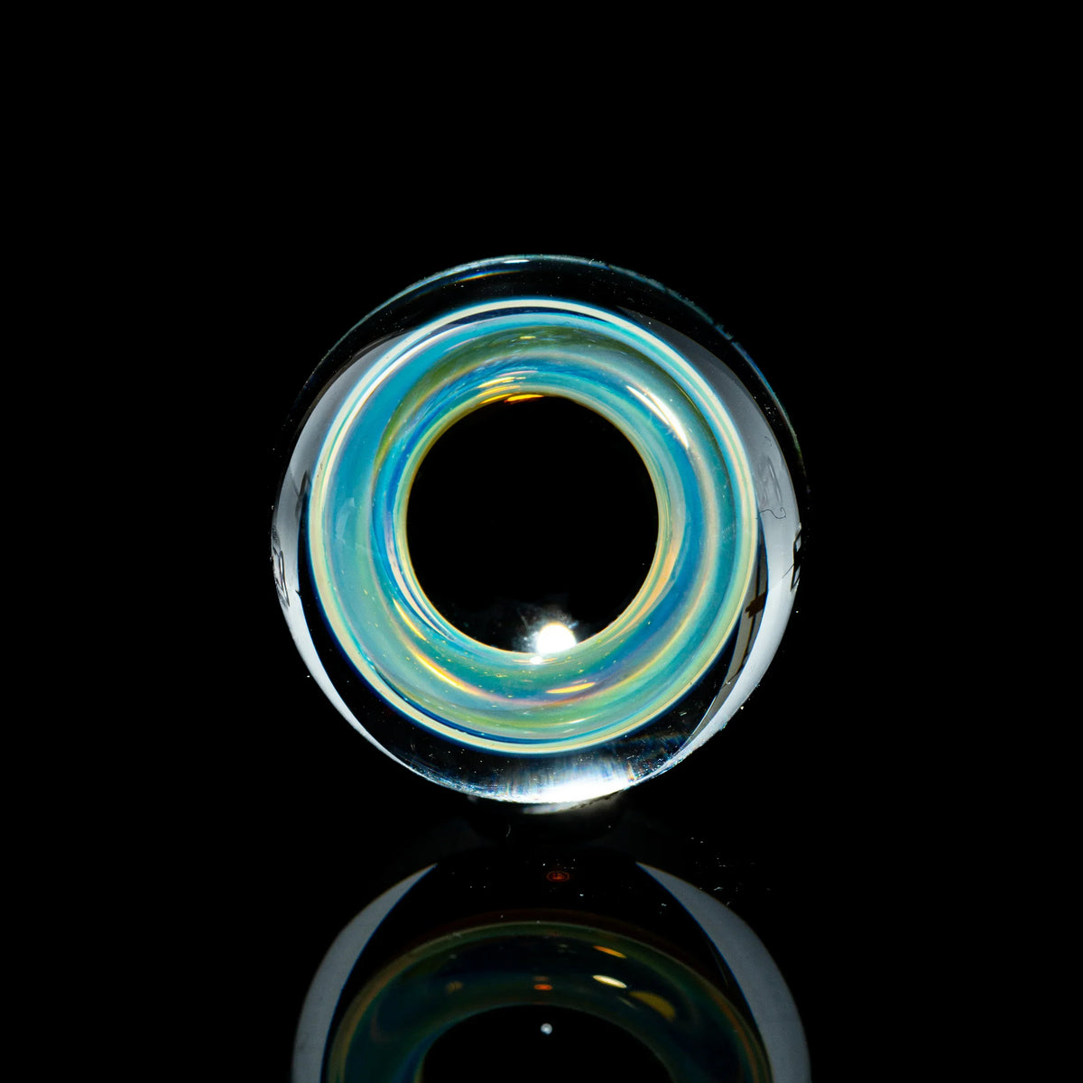 Toroidal top marble with blue and yellow glass ring on black background