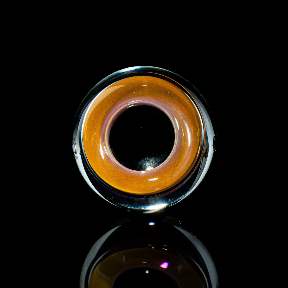 Toroidal top glass marble with orange and clear design on black background