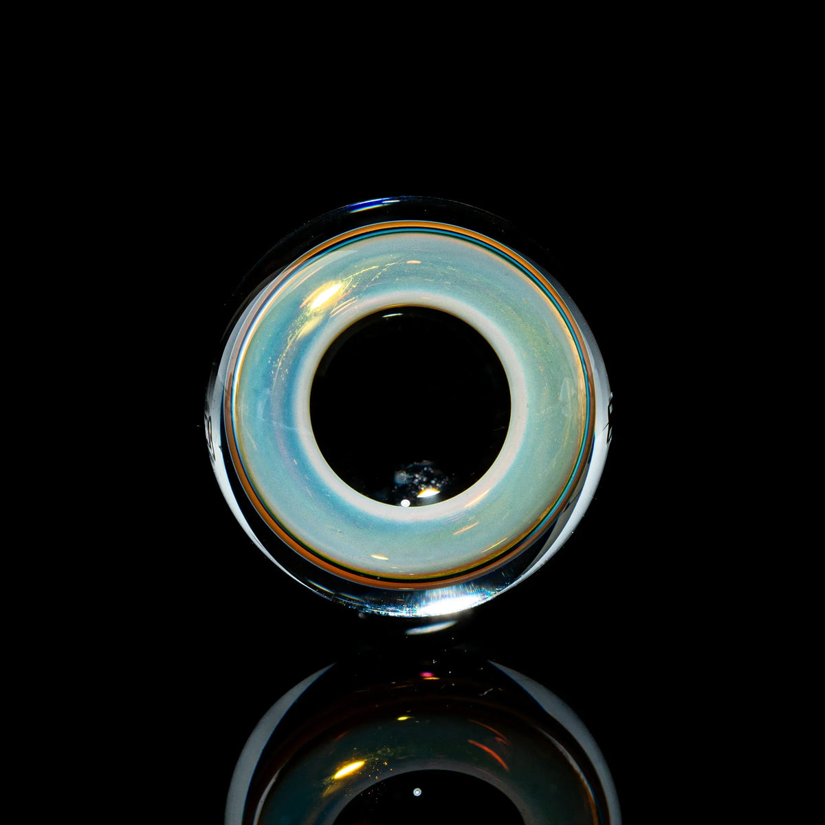 Toroidal glass marble with opalescent ring, black background, artistic smoking accessory