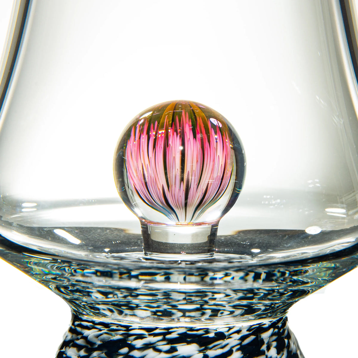 Close-up of heady glass marble with pink flower design inside a clear glass piece