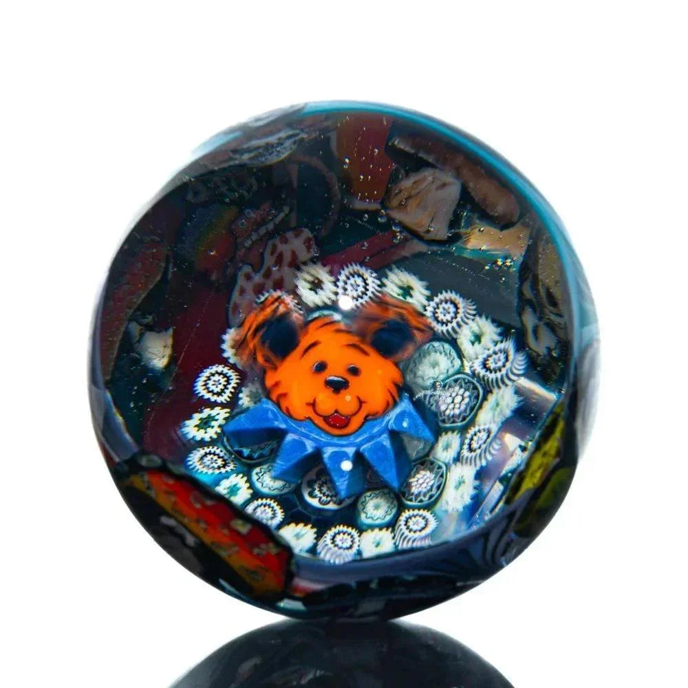 Handcrafted glass marble featuring an orange bear design with intricate millefiori accents.