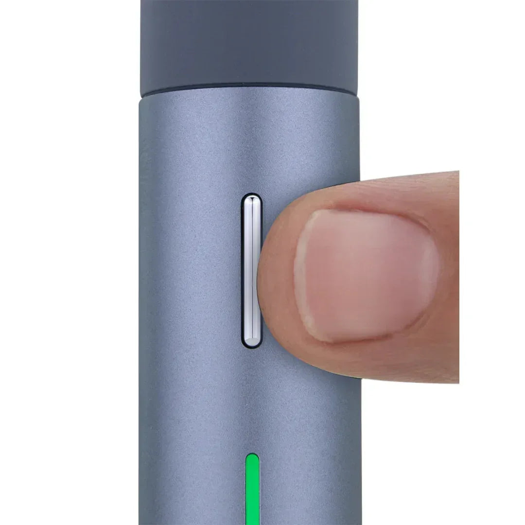 Close-up of a person pressing the button on a sleek vaporizer with LED indicator