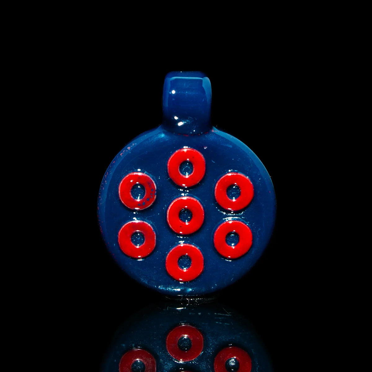Handmade blue glass pendant with red donut pattern on black background