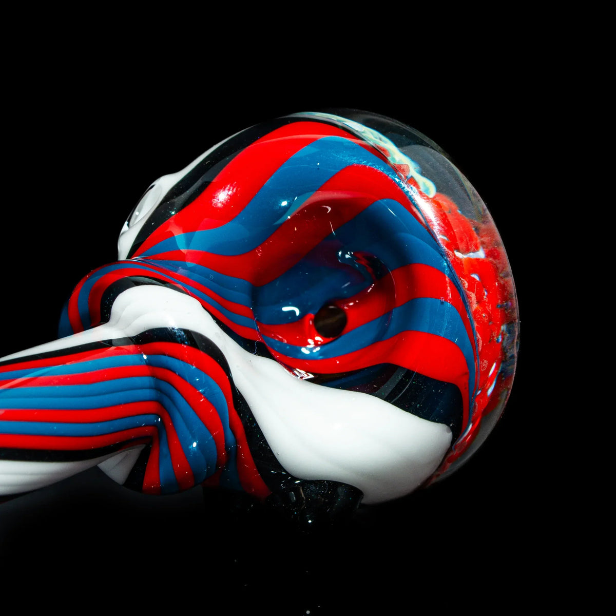 Red, blue, and white linework glass hand pipe with swirl pattern on black background