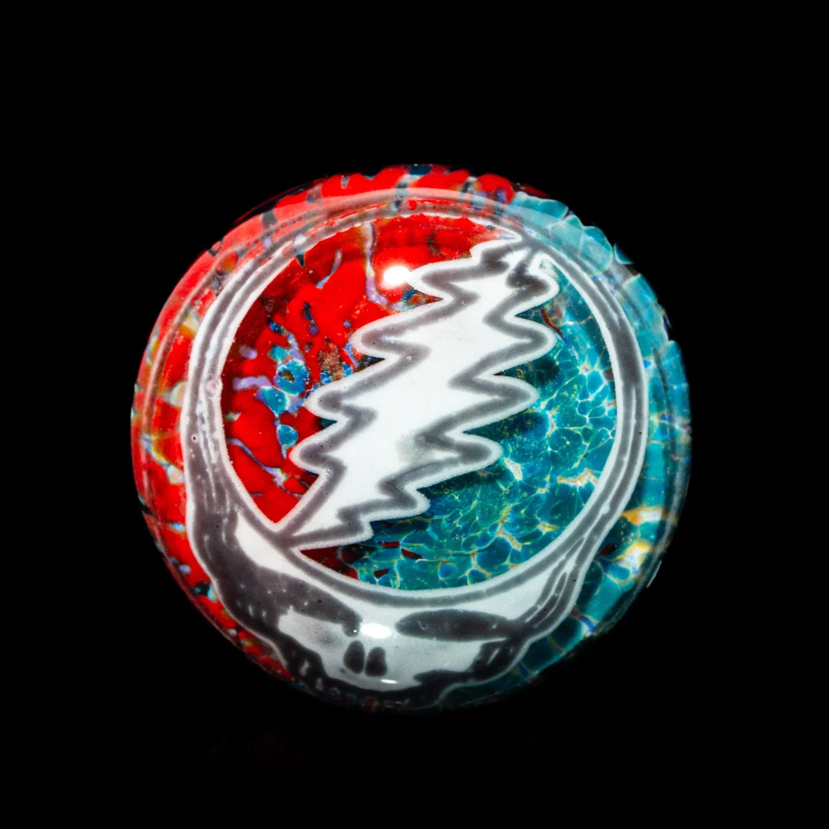 Handcrafted glass cabochon with red, blue, and white Steal Your Face skull design