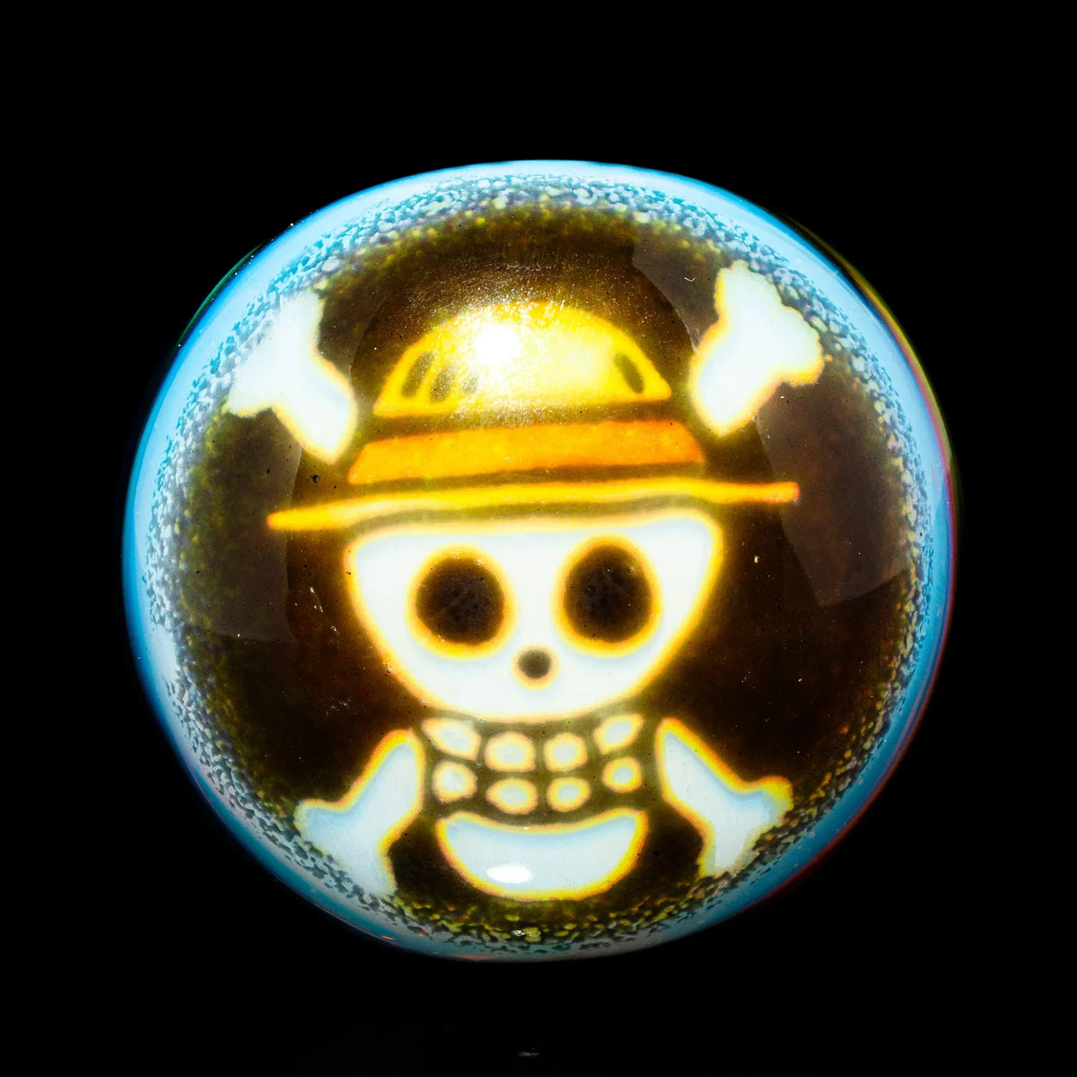Glass spoon pipe featuring a detailed cartoon skull with crossbones and hat design