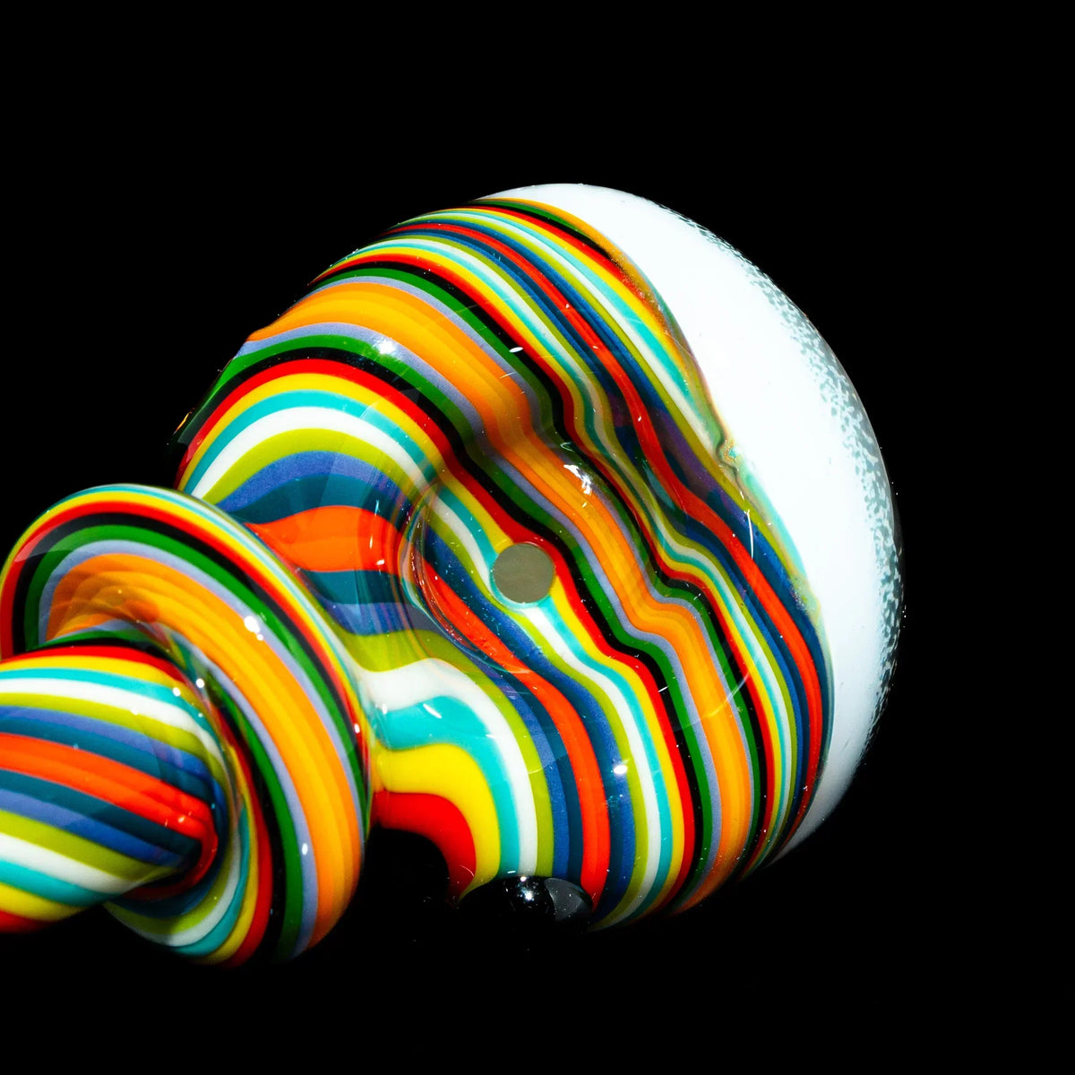 Colorful rainbow glass spoon pipe with white accents on a black background