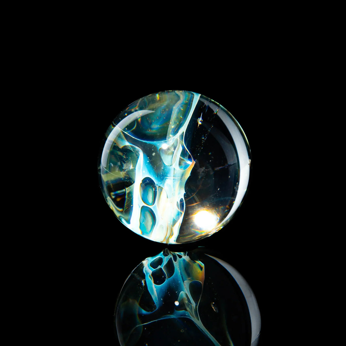 Heady glass marble with intricate blue and white patterns, displayed on a black background.