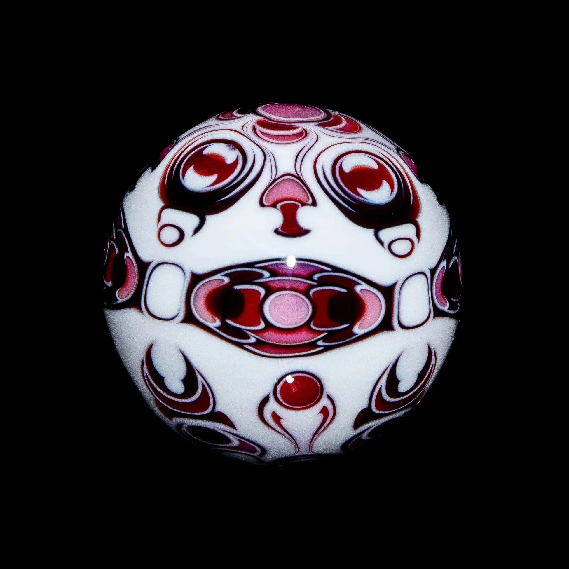 Pink and white glass marble with intricate abstract patterns on black background