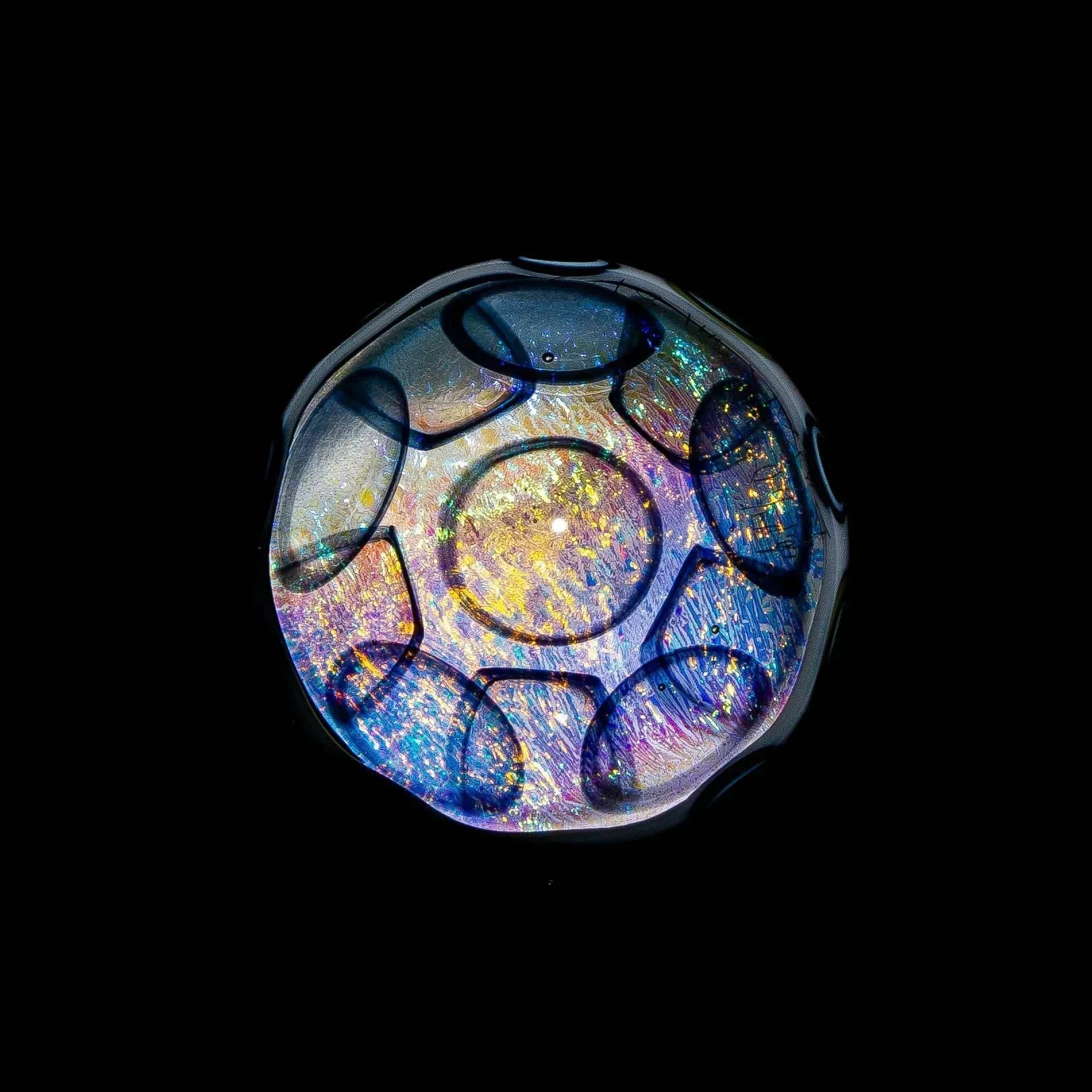 Colorful heady glass art piece with iridescent, holographic patterns on black background