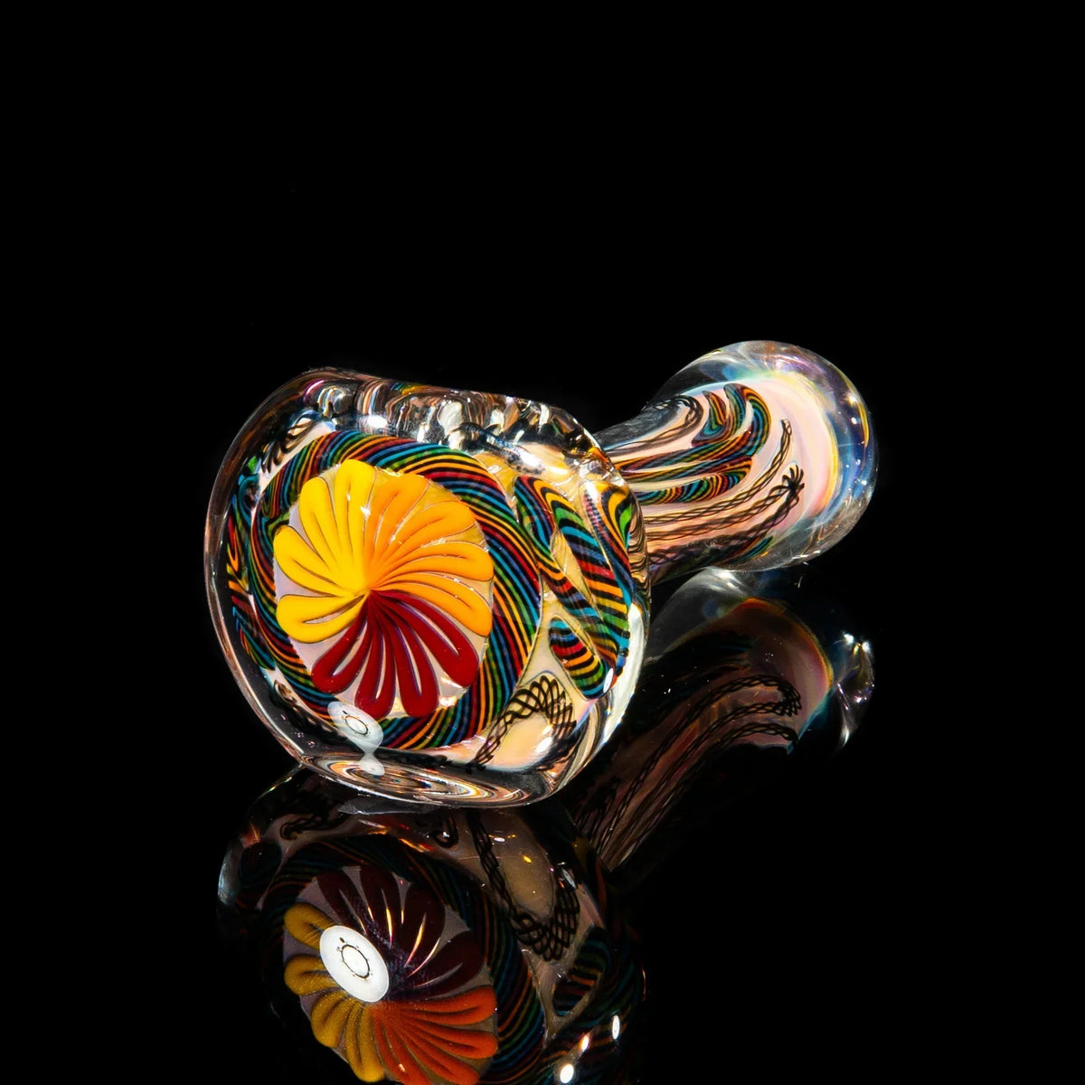 Handcrafted glass pipe with black rainbow cane and colorful floral design on a glossy black background
