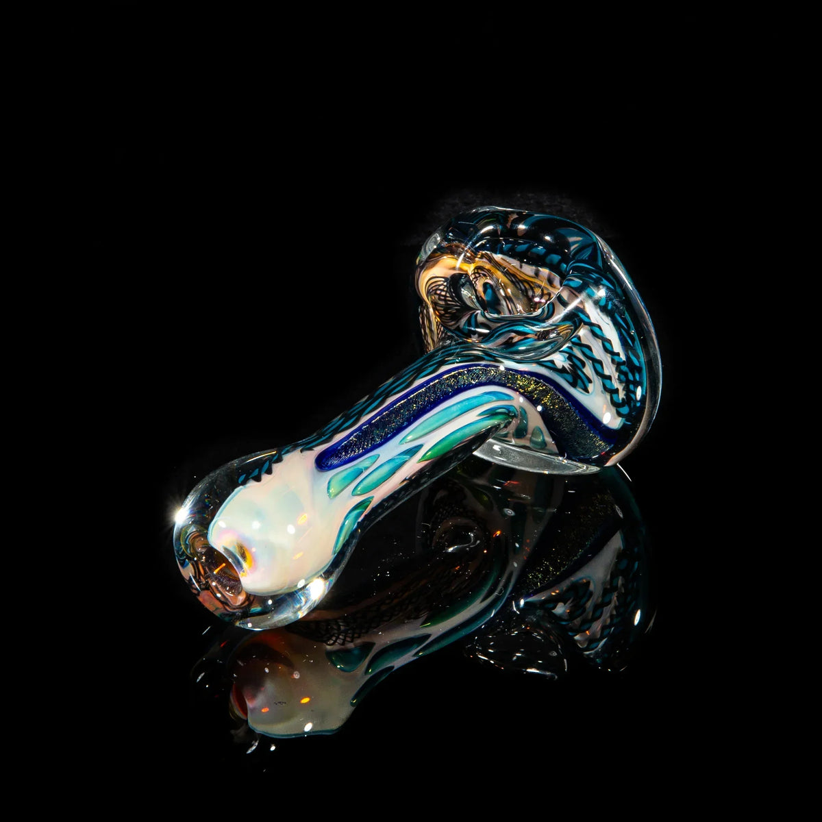 Blue and gold dichroic glass spoon pipe with swirling patterns on black reflective background