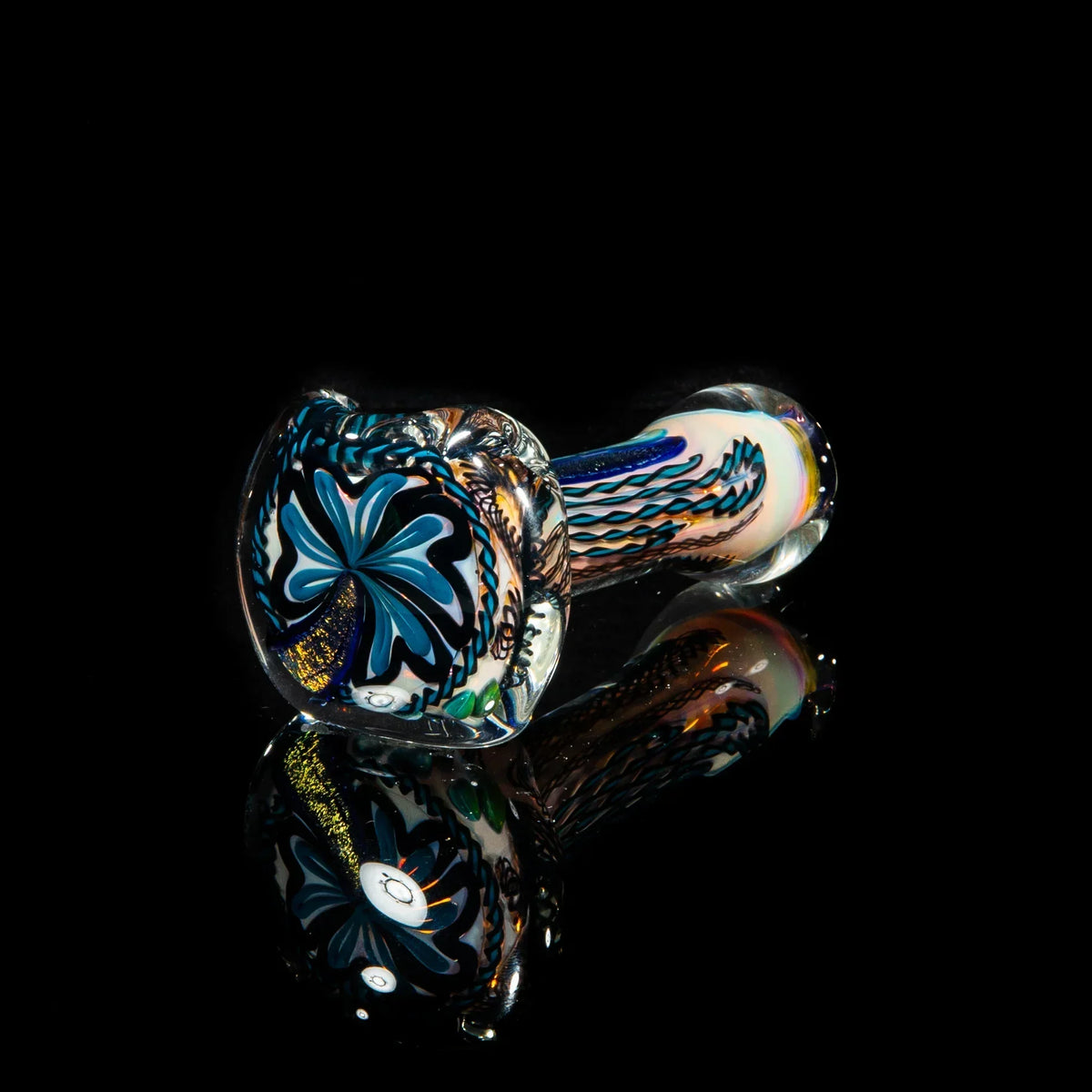 Blue and gold dichroic glass spoon pipe with intricate swirled design on black background