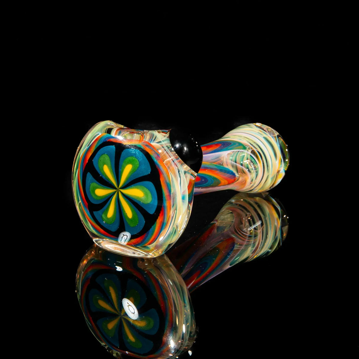 Hand-blown glass pipe with blue, green, and yellow flower pattern on glossy black background