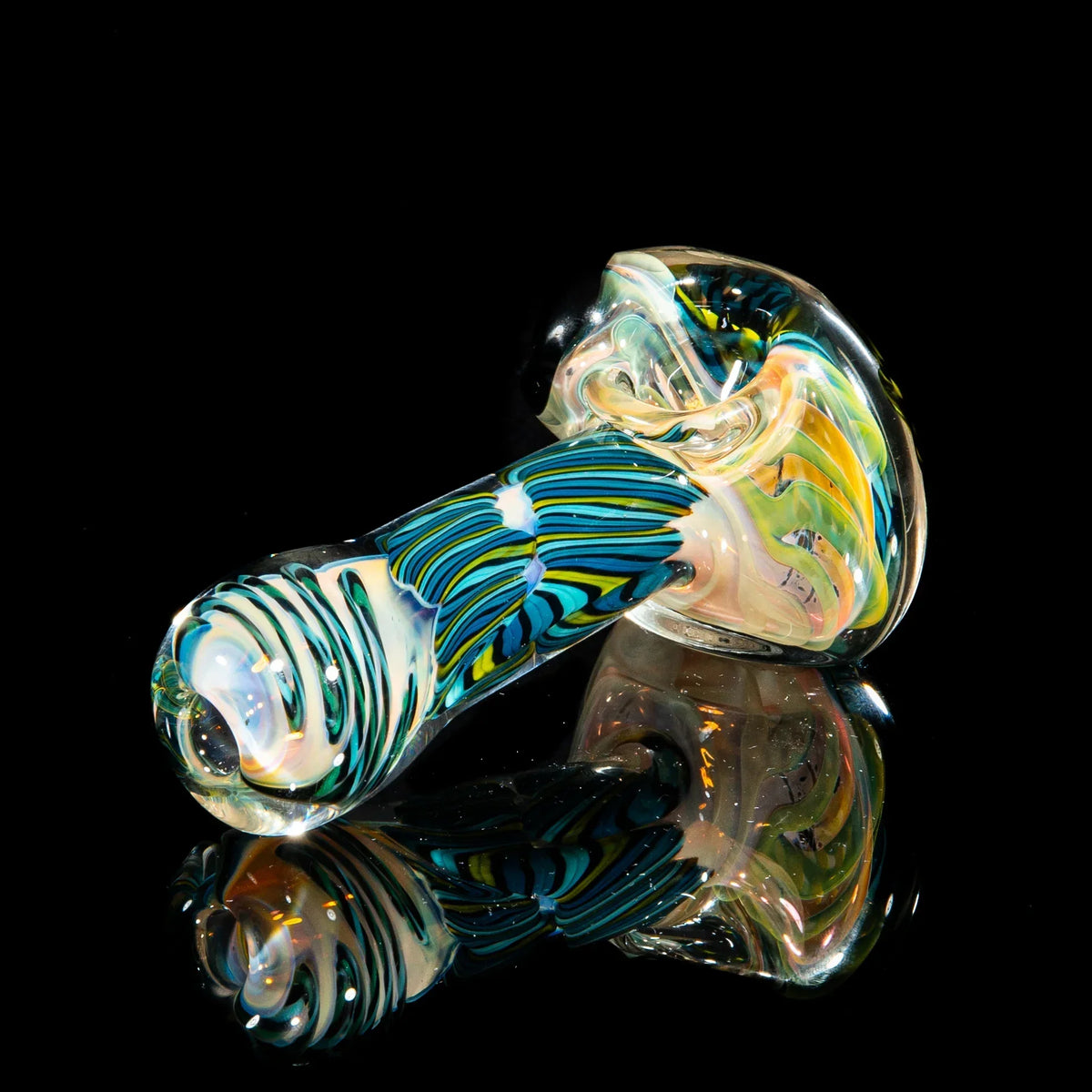 Colorful reticello glass spoon pipe with teal, blue, and chartreuse patterns on black background