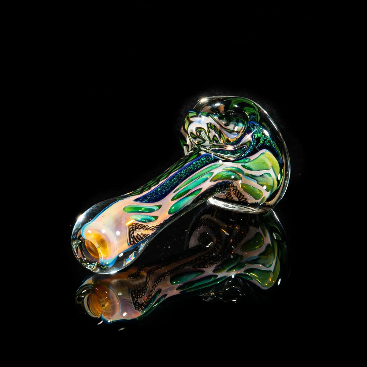 Colorful glass spoon pipe with green dichroic striping on a reflective black background