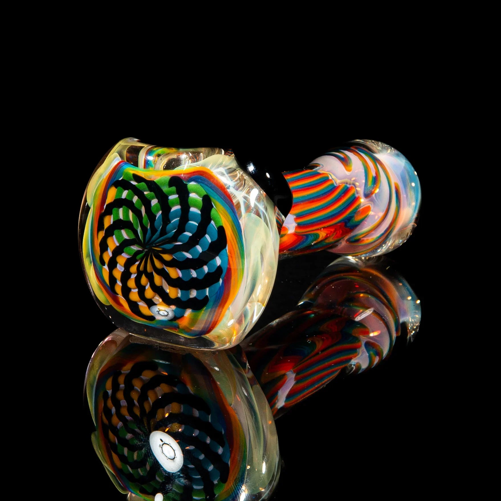 Colorful glass pipe with green, yellow, and blue reticello spiral design on black background.