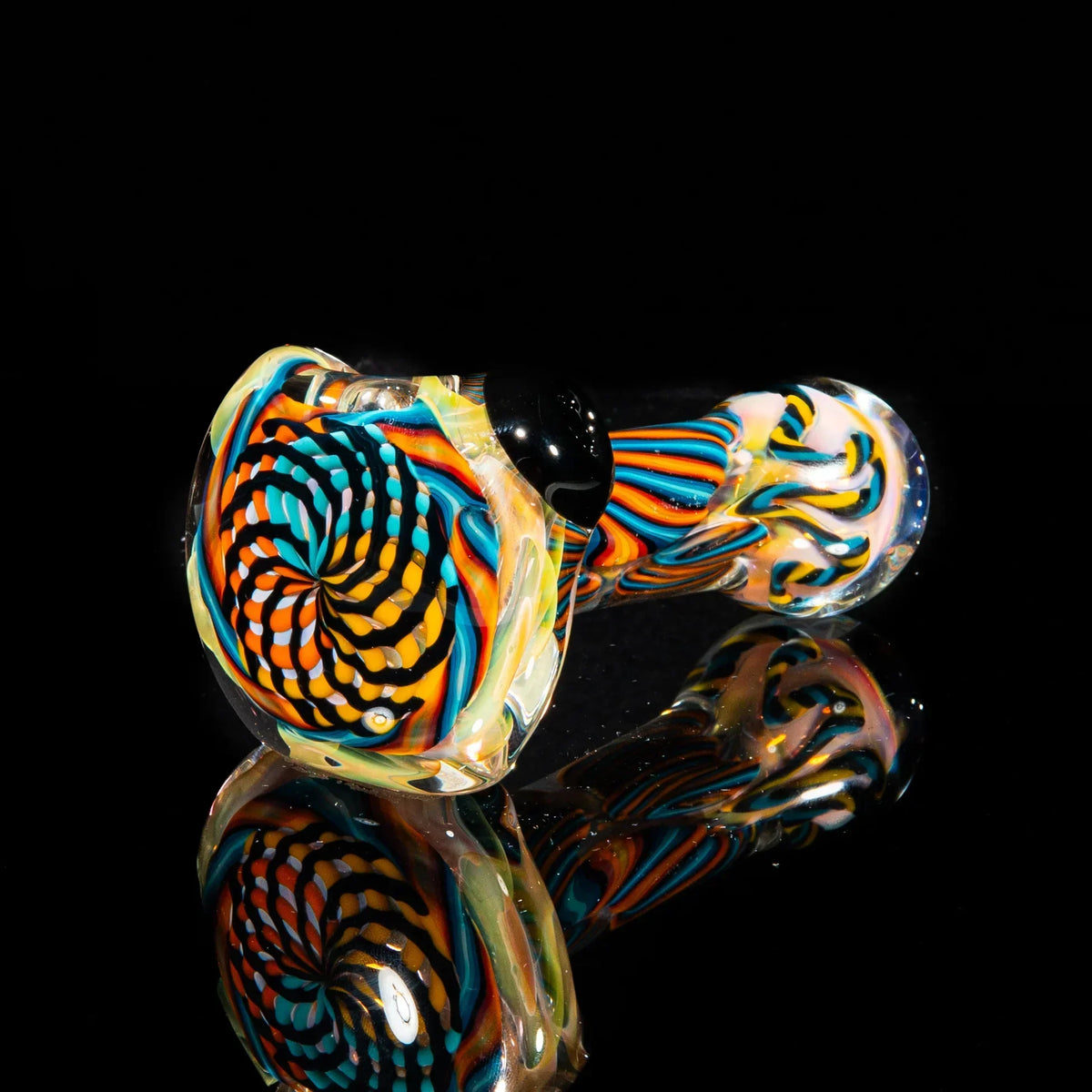 Colorful reticello glass hand pipe with orange, yellow, and teal spiral pattern on black background