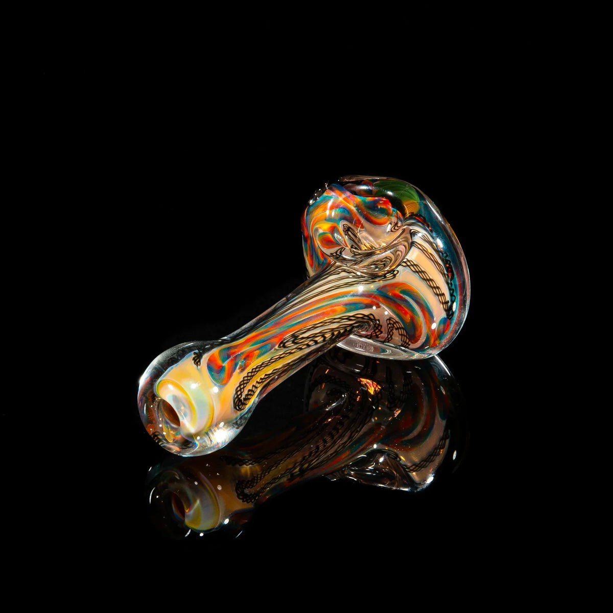 Colorful hand-blown glass spoon pipe with yellow, blue, and green cane design on black background