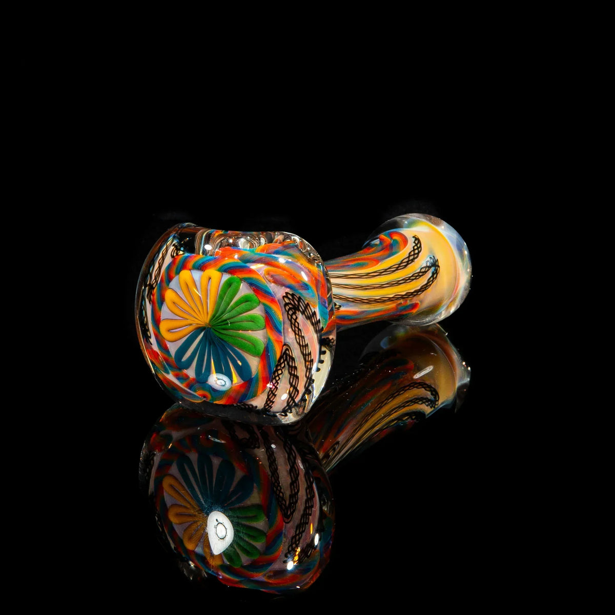Heady glass spoon pipe with yellow, blue, and green cane design on black background