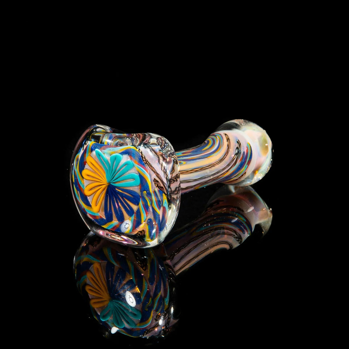 Handcrafted glass spoon pipe with yellow, teal, and purple swirl patterns on black background