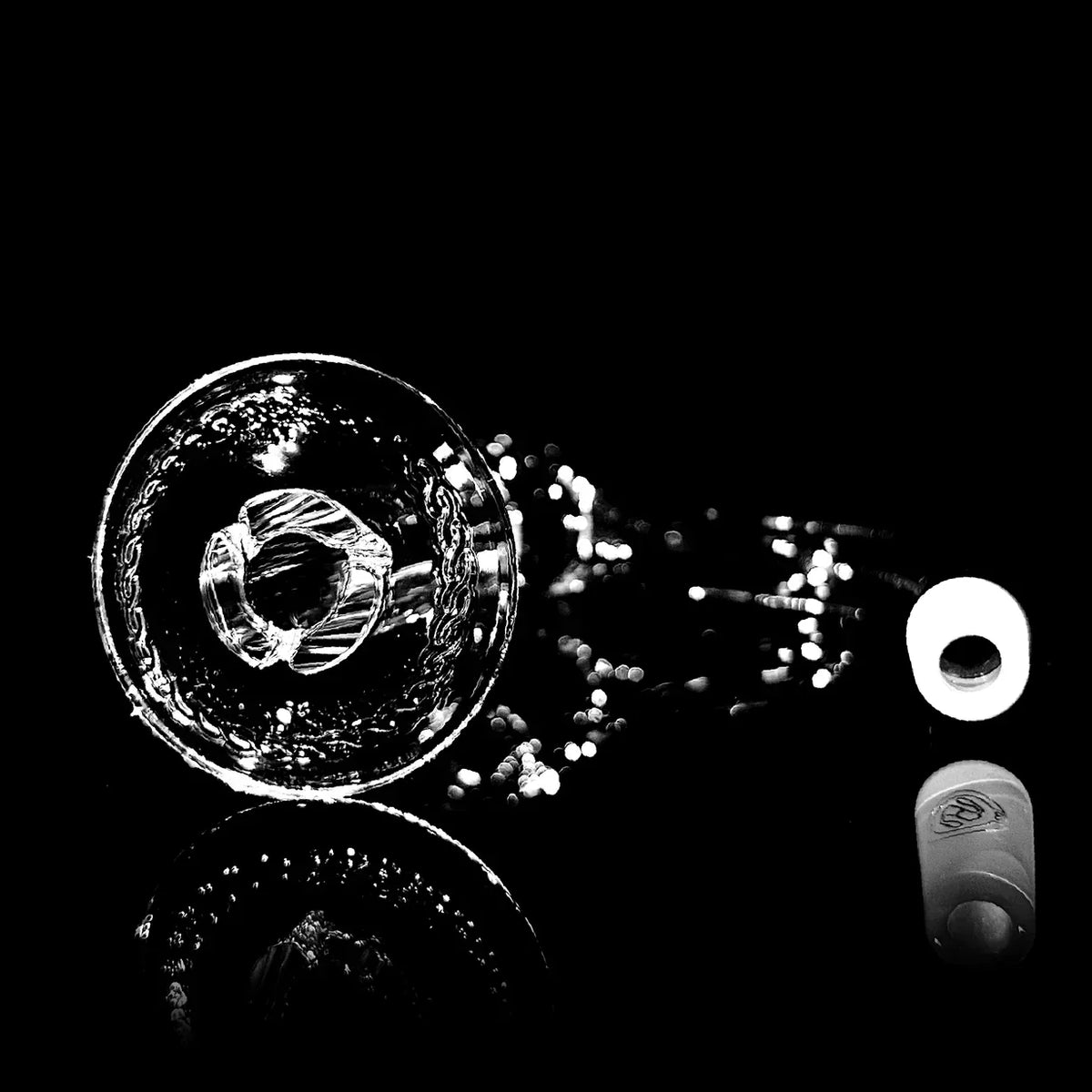Heady glass bowl with intricate design and reflective surface on black background