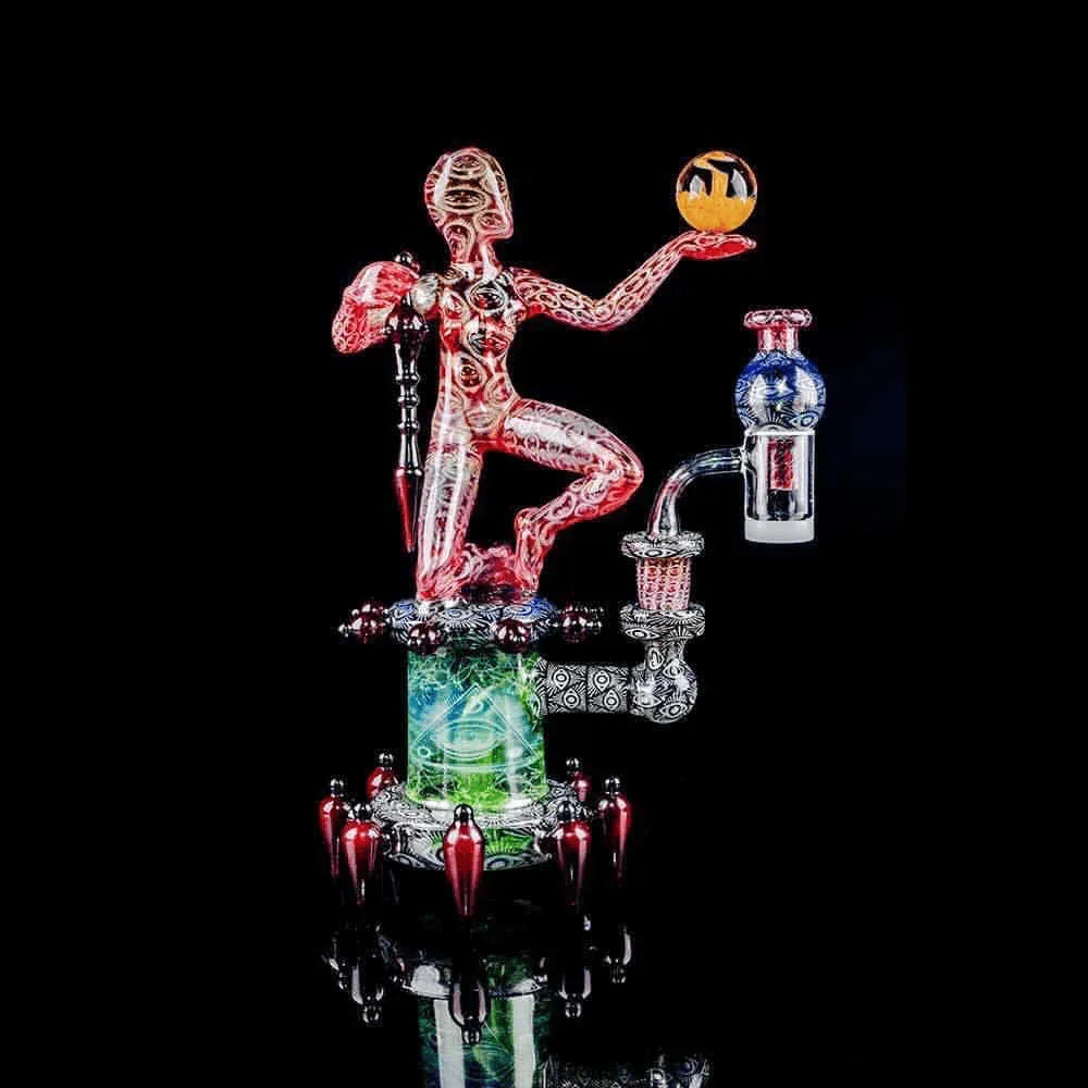 Intricate heady glass dab rig featuring a humanoid figure and vibrant colors on black background