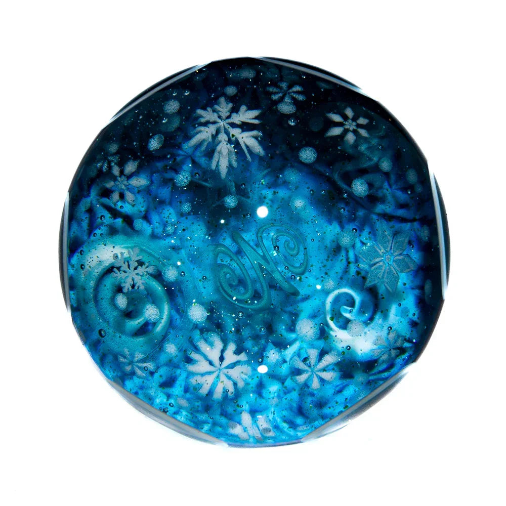 Blue glass art piece with etched snowflakes and swirling designs