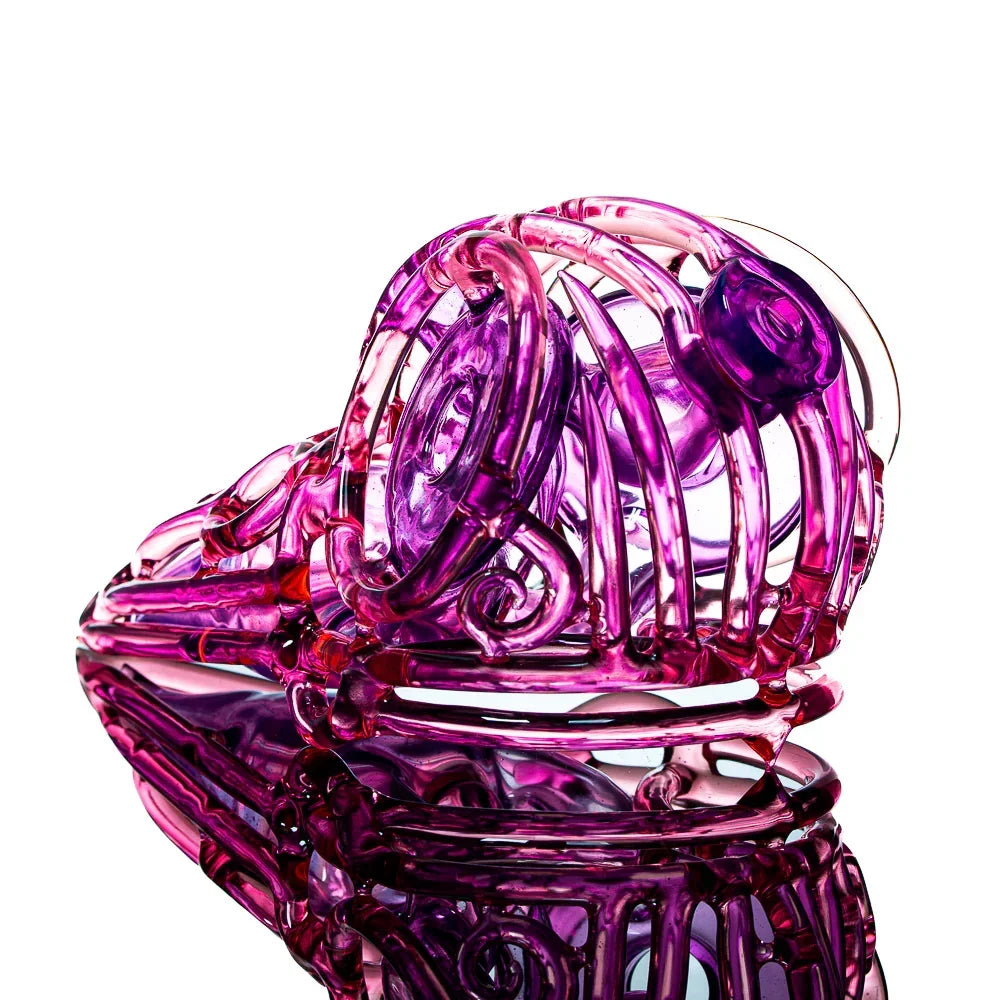 Intricate pink glass skull pipe with artistic swirls, displayed on reflective surface.