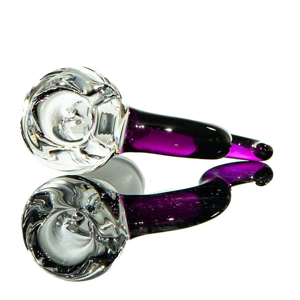 Purple and clear glass smoking pipe with intricate swirl design, reflected on white surface