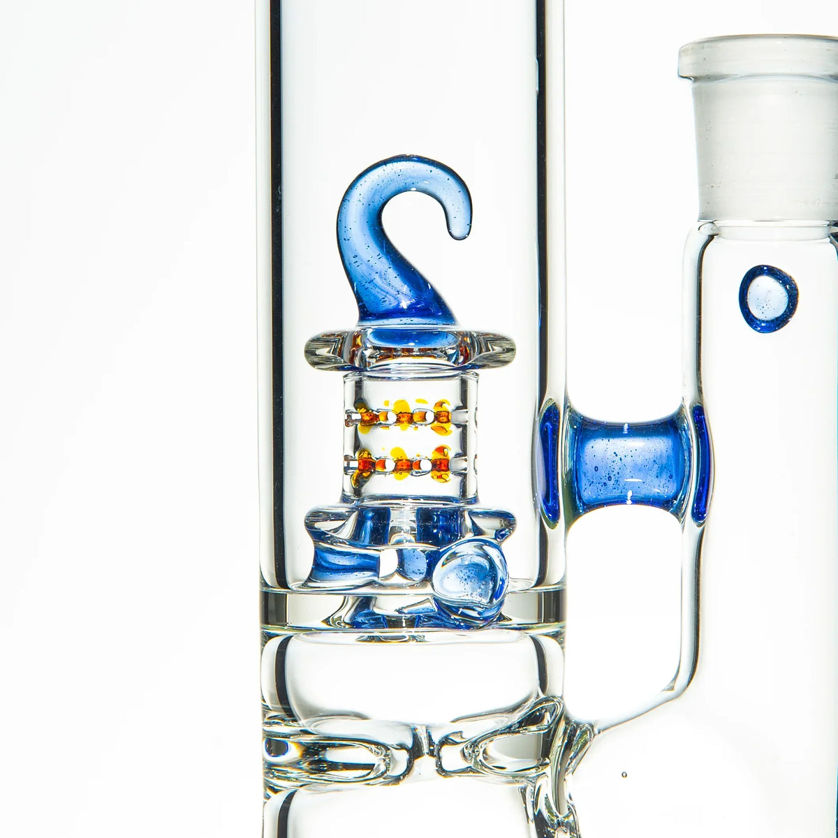 Close-up of a clear glass water pipe with blue accents and intricate glasswork detail