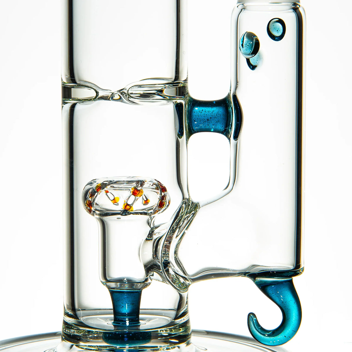 Close-up of clear glass water pipe with blue stardust accents and intricate glasswork.