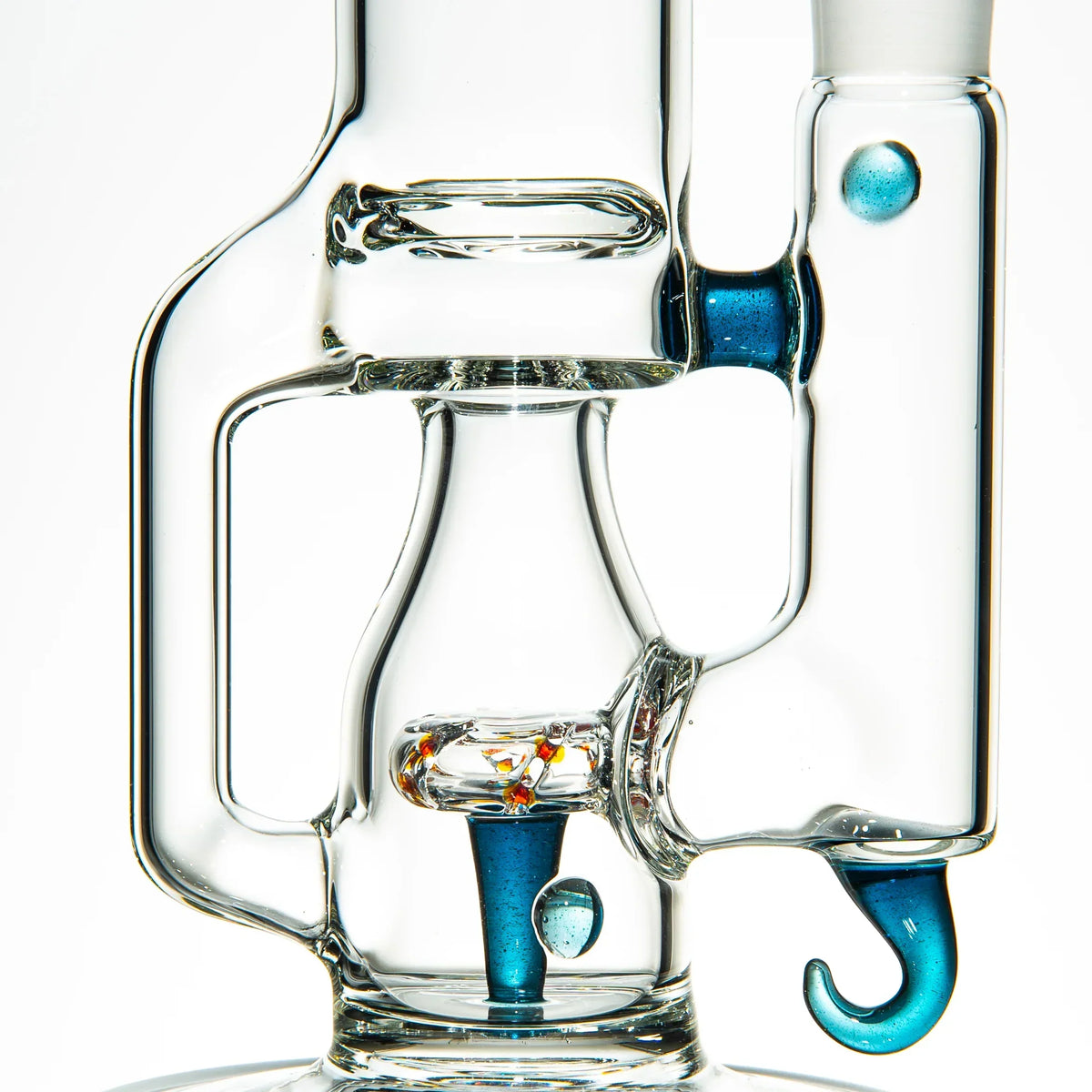 Close-up of a clear glass water pipe with blue stardust accents and a unique hook design.