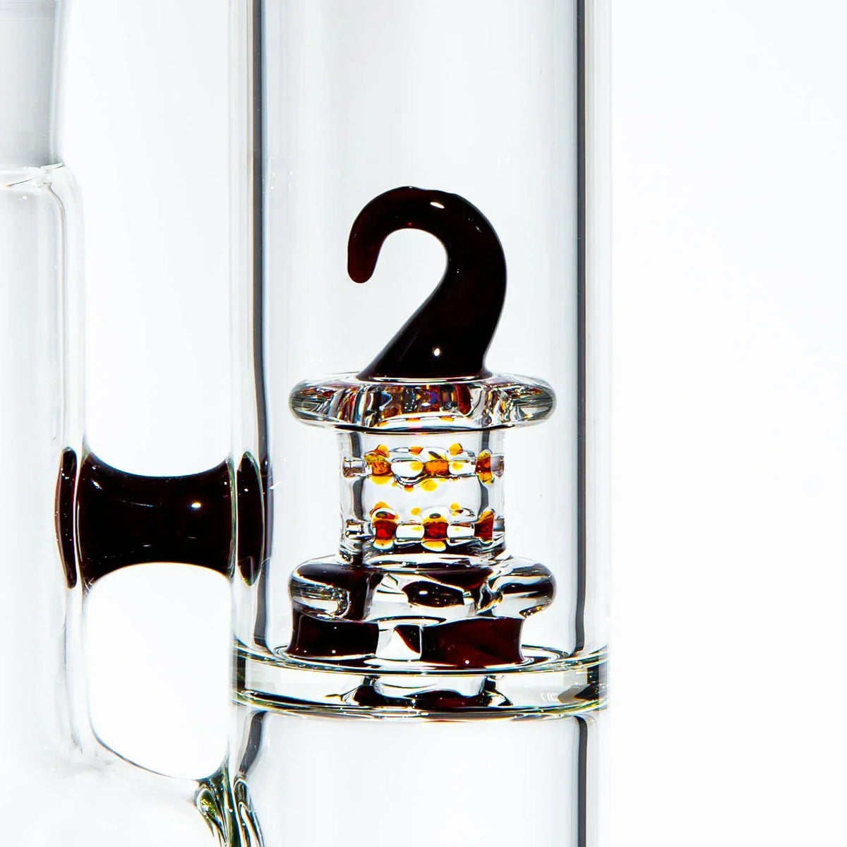 Close-up of a clear glass water pipe with an artistic hook and colored bead accents