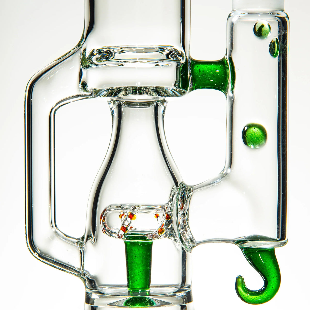 Close-up of unique clear glass water pipe with green accents and intricate design details.