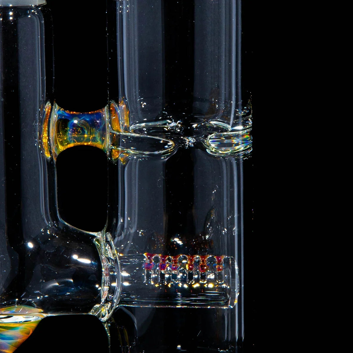 Close-up of artistic clear glass water pipe with yellow accents and decorative percolator.