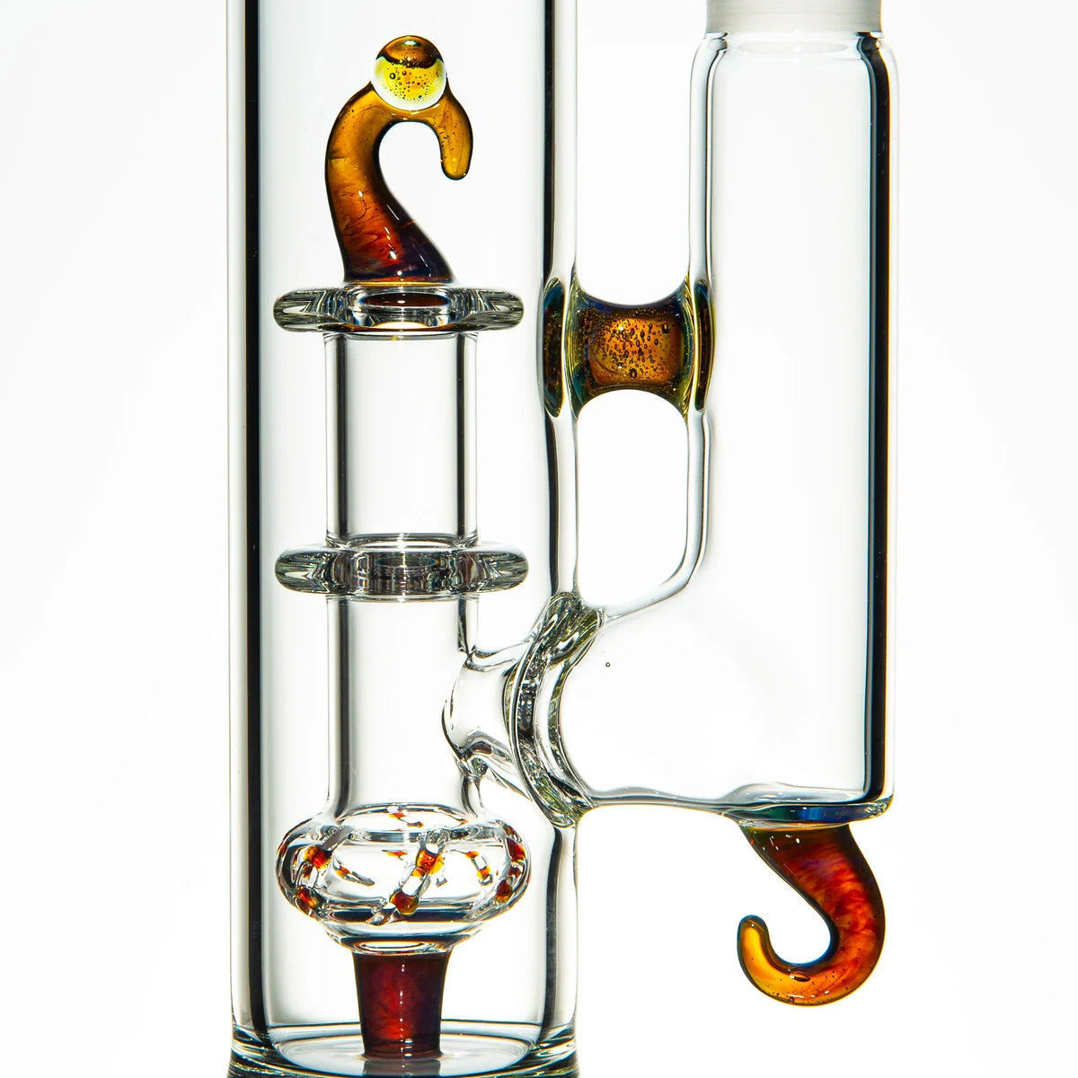 Close-up of a clear heady glass water pipe with orange hook-shaped accents.