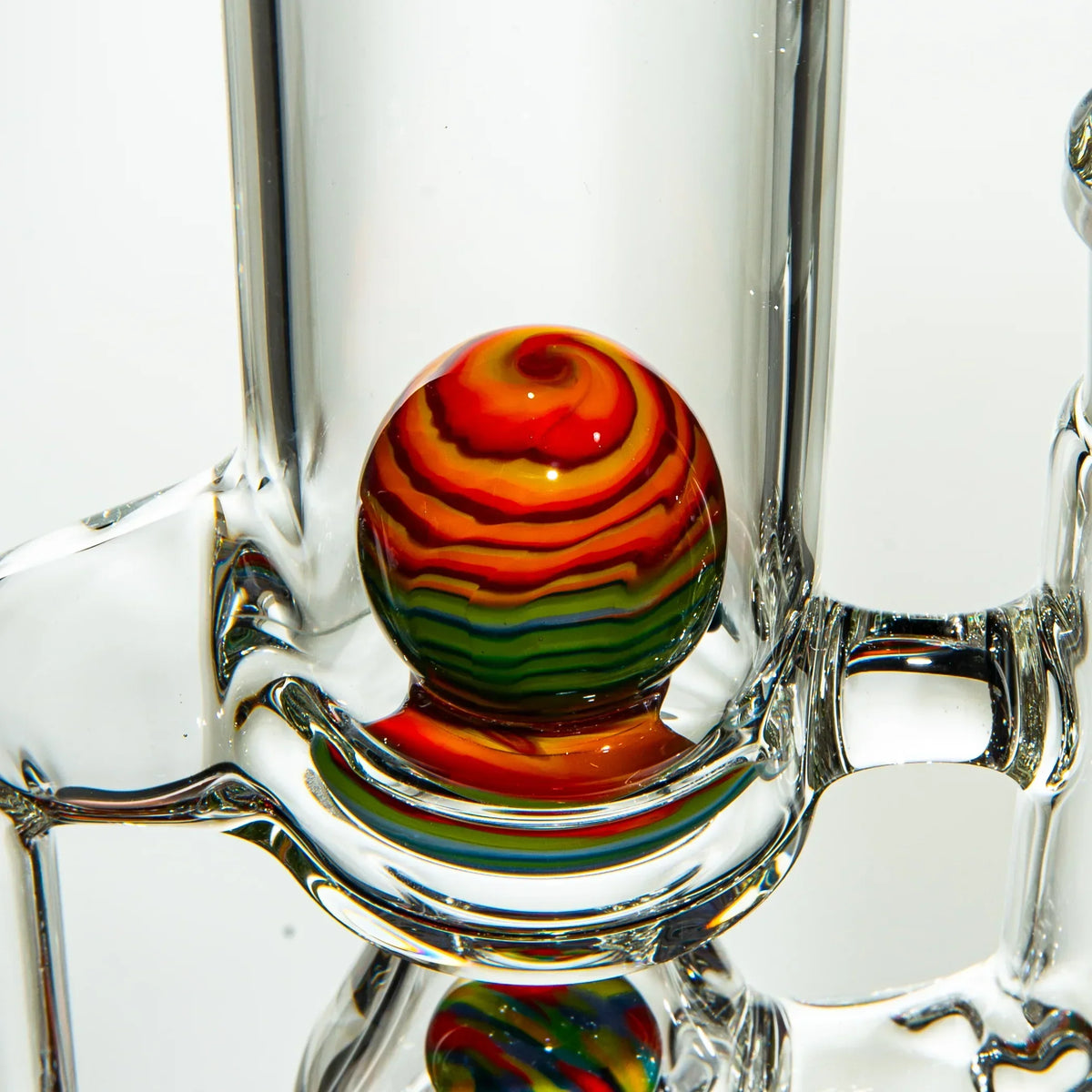 Close-up of a heady glass water pipe with a vibrant rainbow swirl marble accent.
