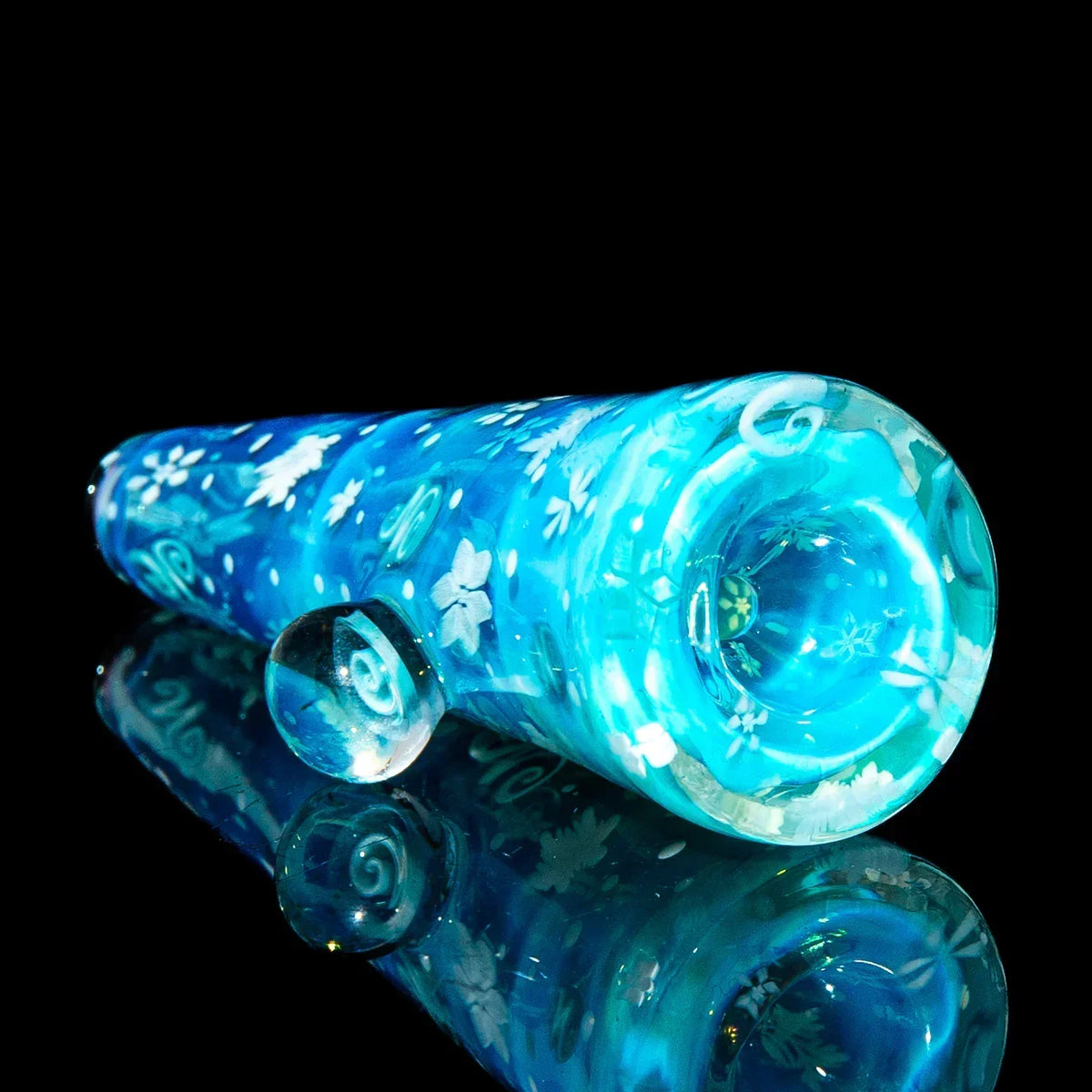 Blue glass chillum with floral patterns, hand-blown smoking accessory on black background