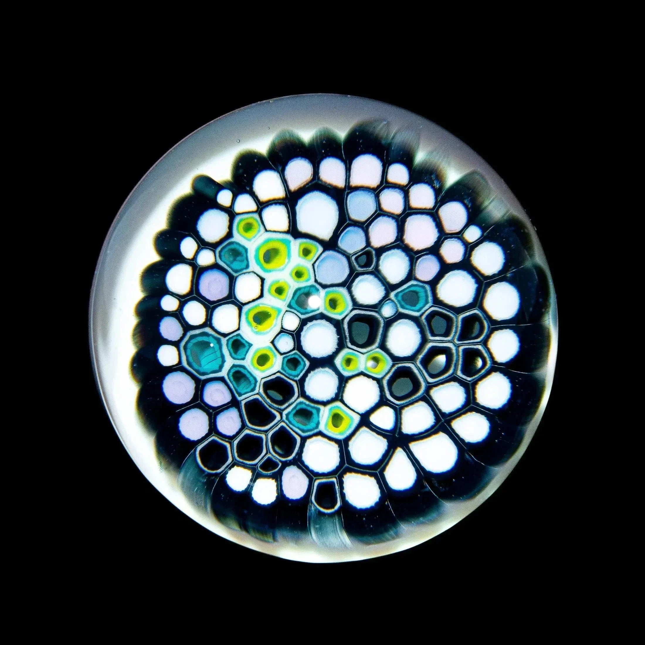 Intricate glass art marble with colorful honeycomb pattern on black background