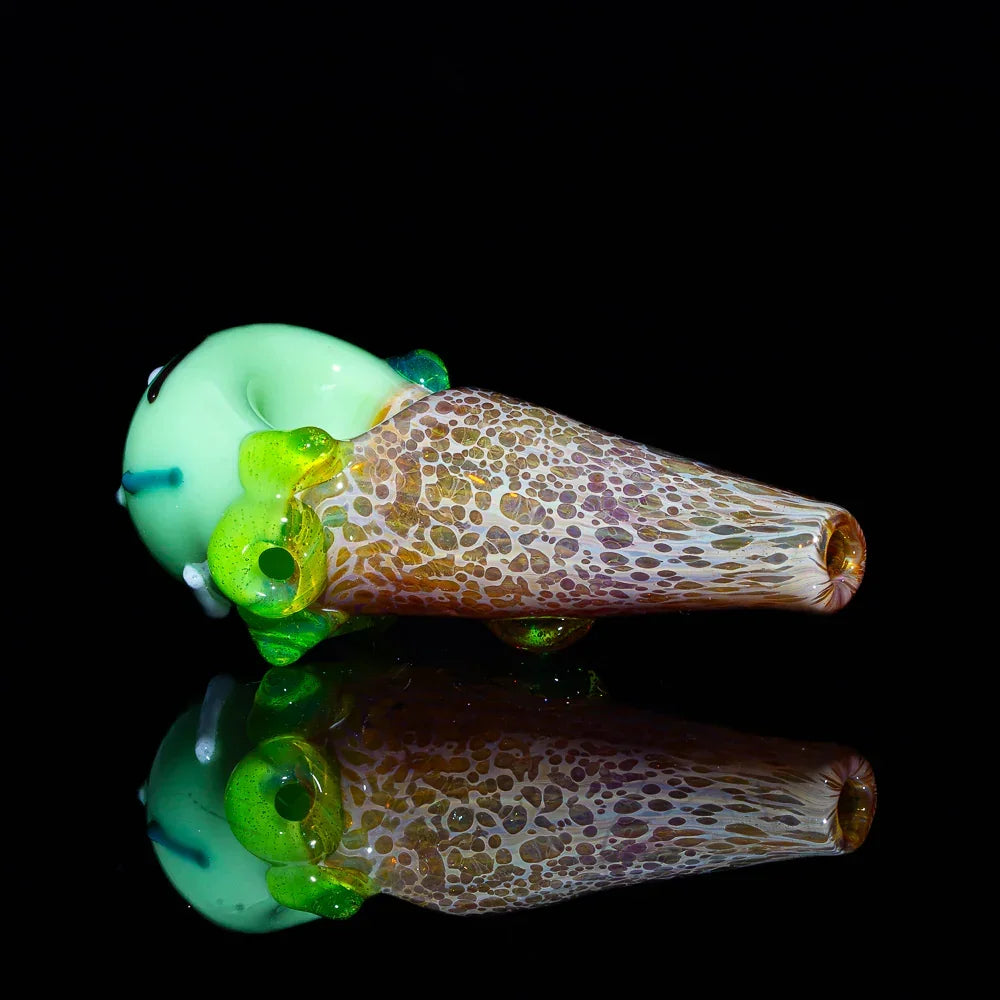 Hand-blown glass pipe shaped like a pistachio ice cream cone on a black background.