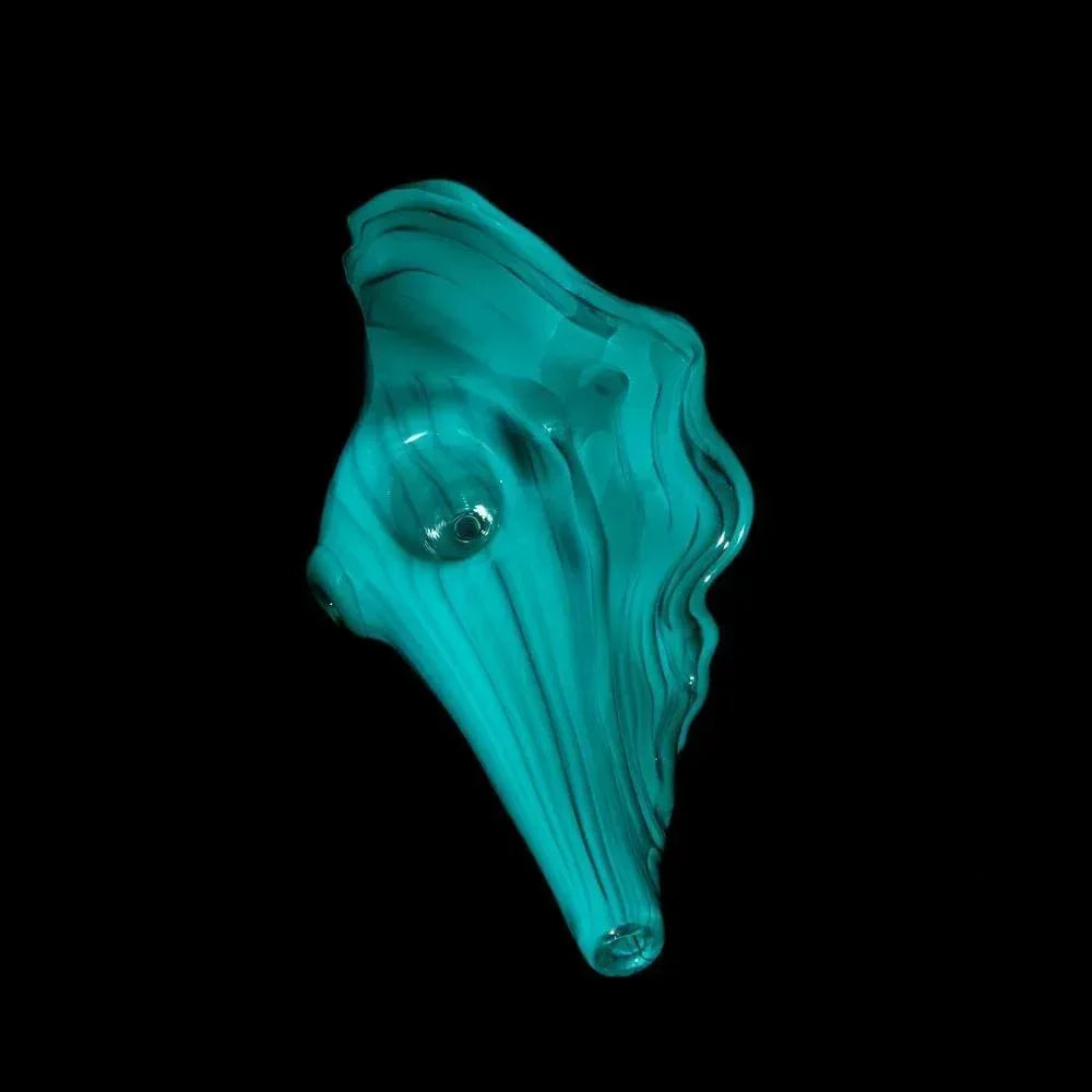Teal glass seashell pipe with detailed swirls on a black background