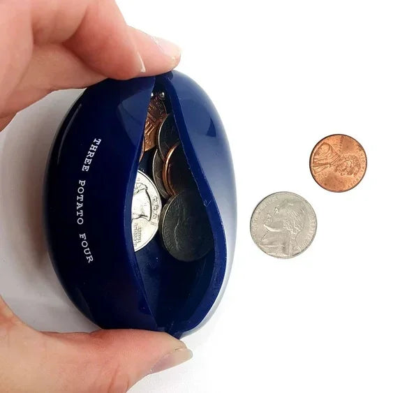 Blue coin pouch with US coins, labeled 'Three Potato Four,' held in hand on white background.