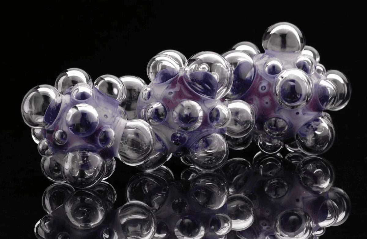 Heady glass pipe with clear and purple bubbled design on black reflective background