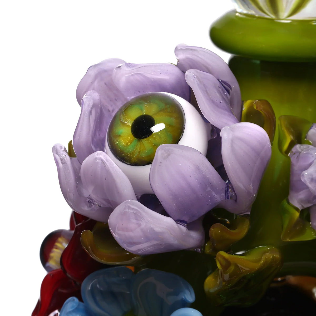 Close-up of a glass art flower with a detailed green eye, purple petals, and colorful accents