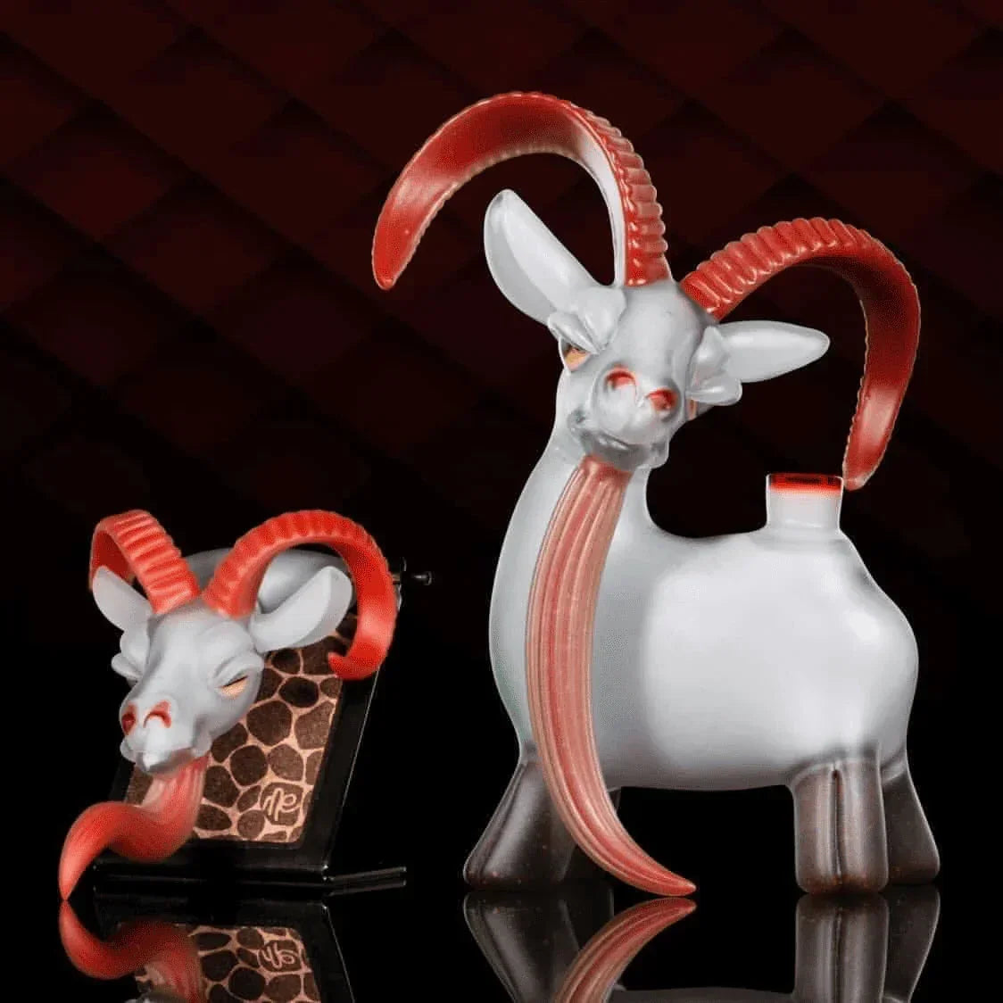 Goat themed glass dab rig and carb cap set with red horns, displayed on a dark background